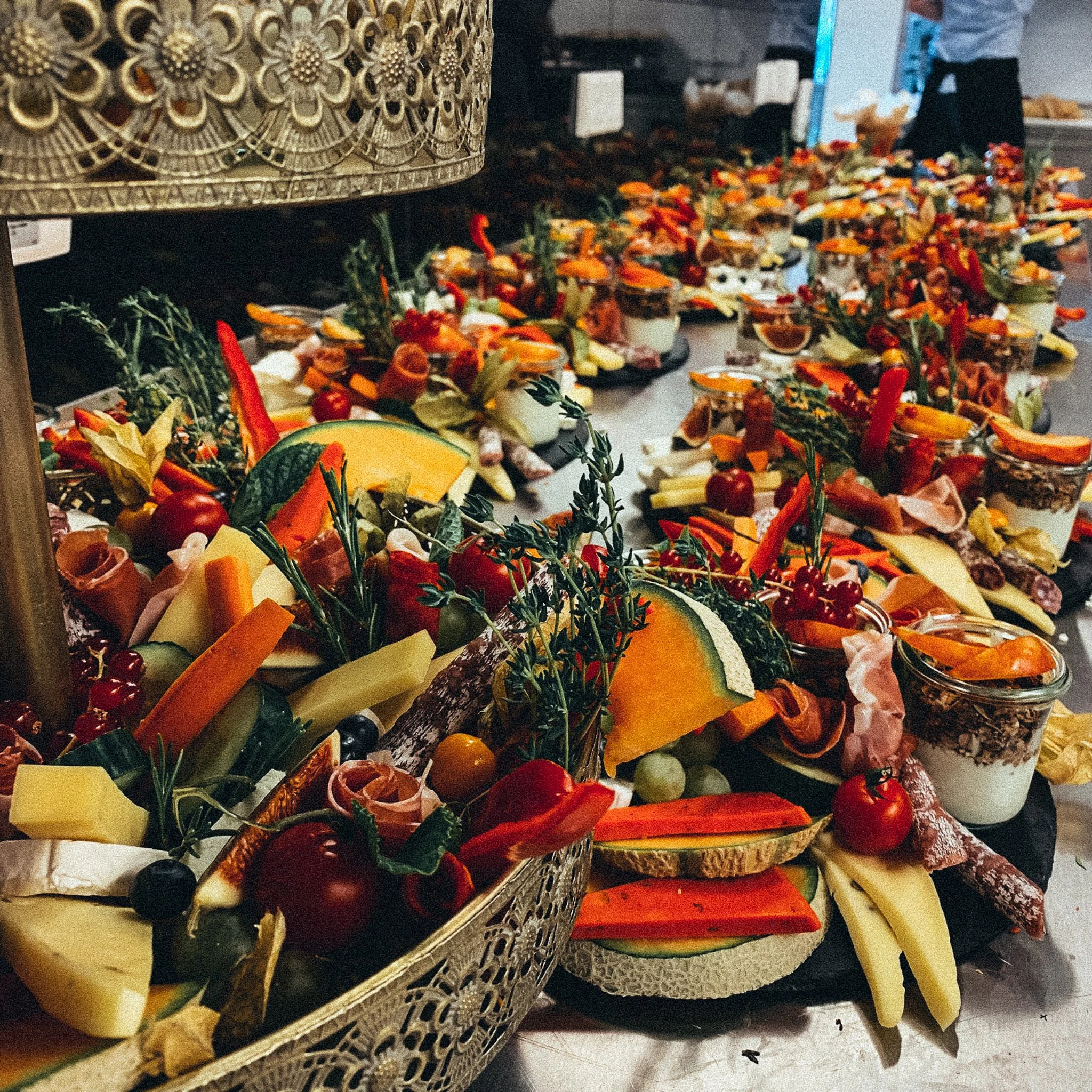 Vielfalt einer kulinarischen Buffetplatte mit Käse, Brot, Aufschnitt, Früchten und Gemüse dekorativ arrangiert.