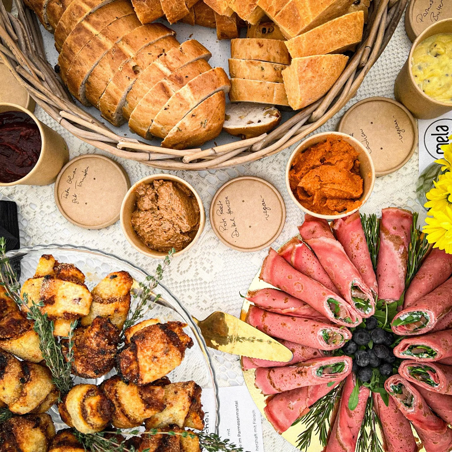 Buffet mit Brot, Dips, gefüllten Röllchen und Gebackenem