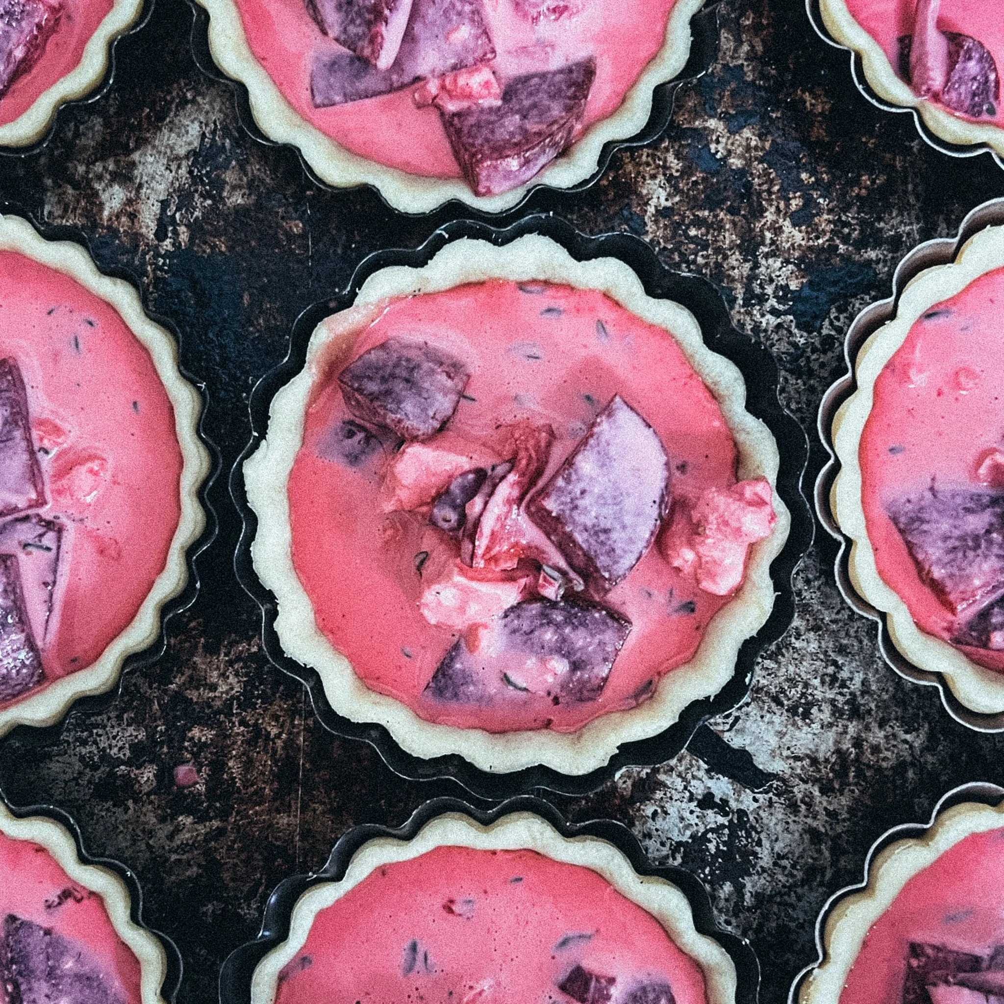 Rote-Bete-Quiches auf einem Backblech, ungebacken.